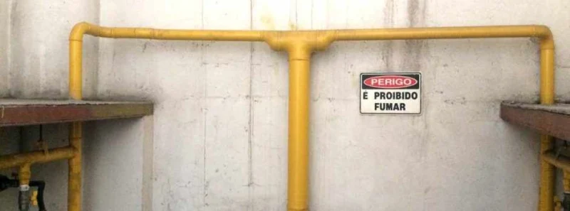 Tubulação de gás em área técnica com placa de segurança